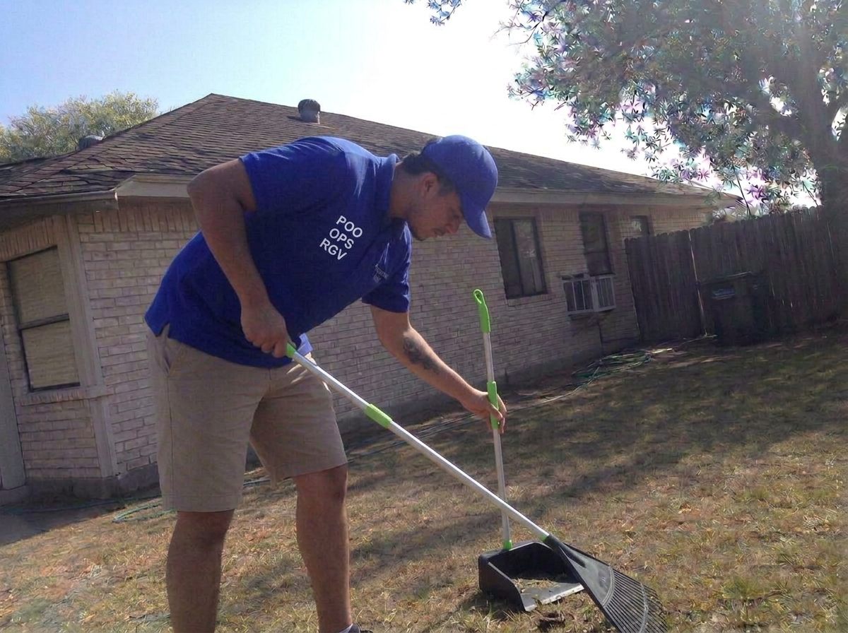 POO OPS RGV technician scooping a backyard while friendly dogs watch